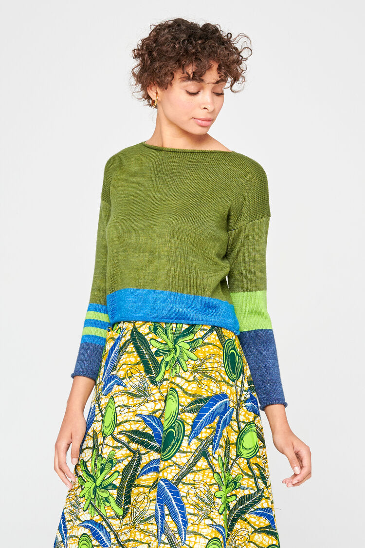 Femme portant un pull en laine merinos extrafine vert jungle.